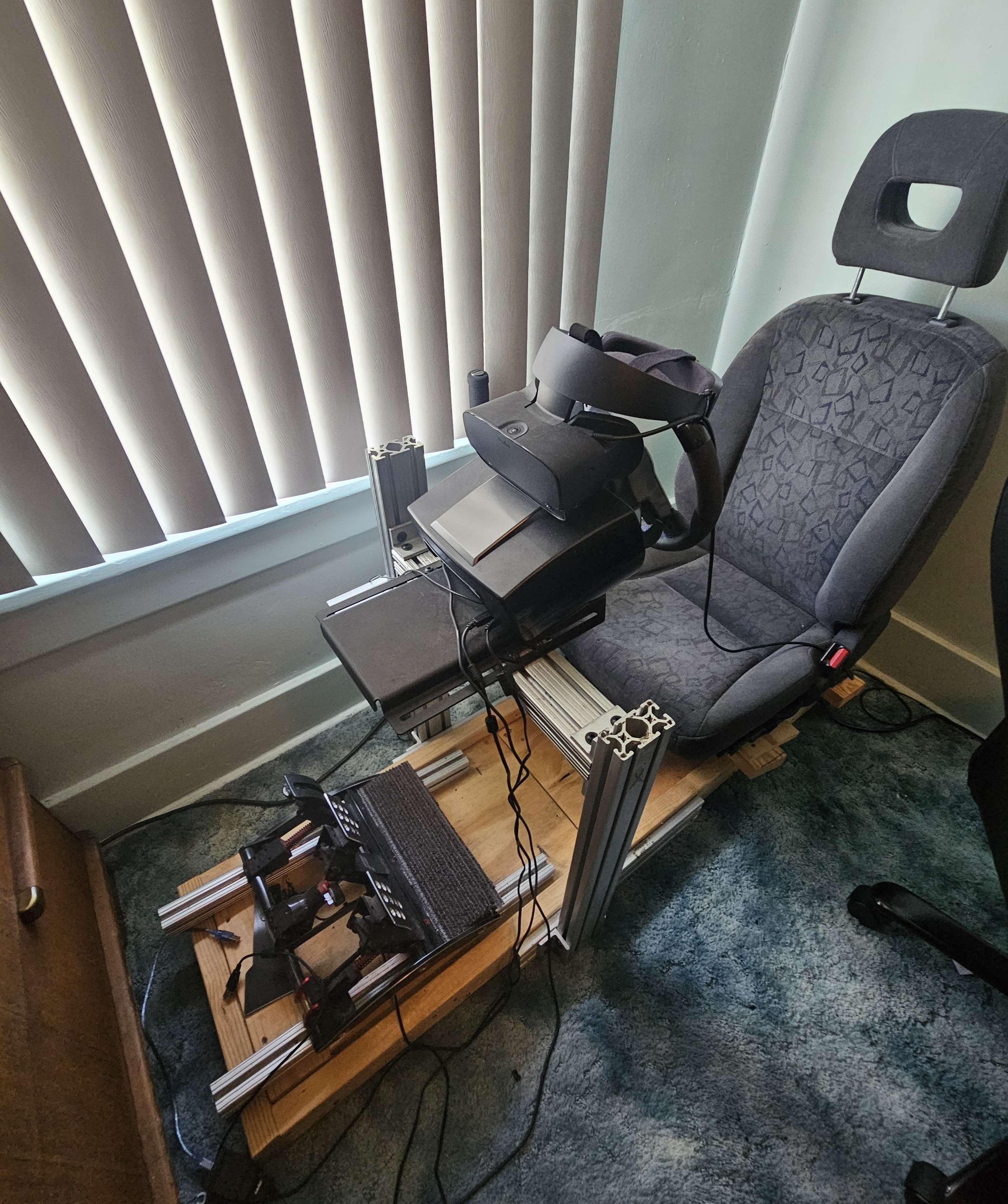 A sturdy and reliable DIY setup for a cockpit / sim rig. The wooden base is sturdy, and the extrusions are added in where needed to keep adjustabiltiy at a maxmimum relative to price. Full X-Y-Z adjustment on the wheelbase & Z adjustment on angled rails for the pedals. Car seat retains their sliders so driving position can be optimizied. 

I'm thinking of switching over to an ultrawide monitor setup, as VR drivers (specifically Oculus drivers) can be a bit of a pain to get working sometimes, at least in my specific use-case.